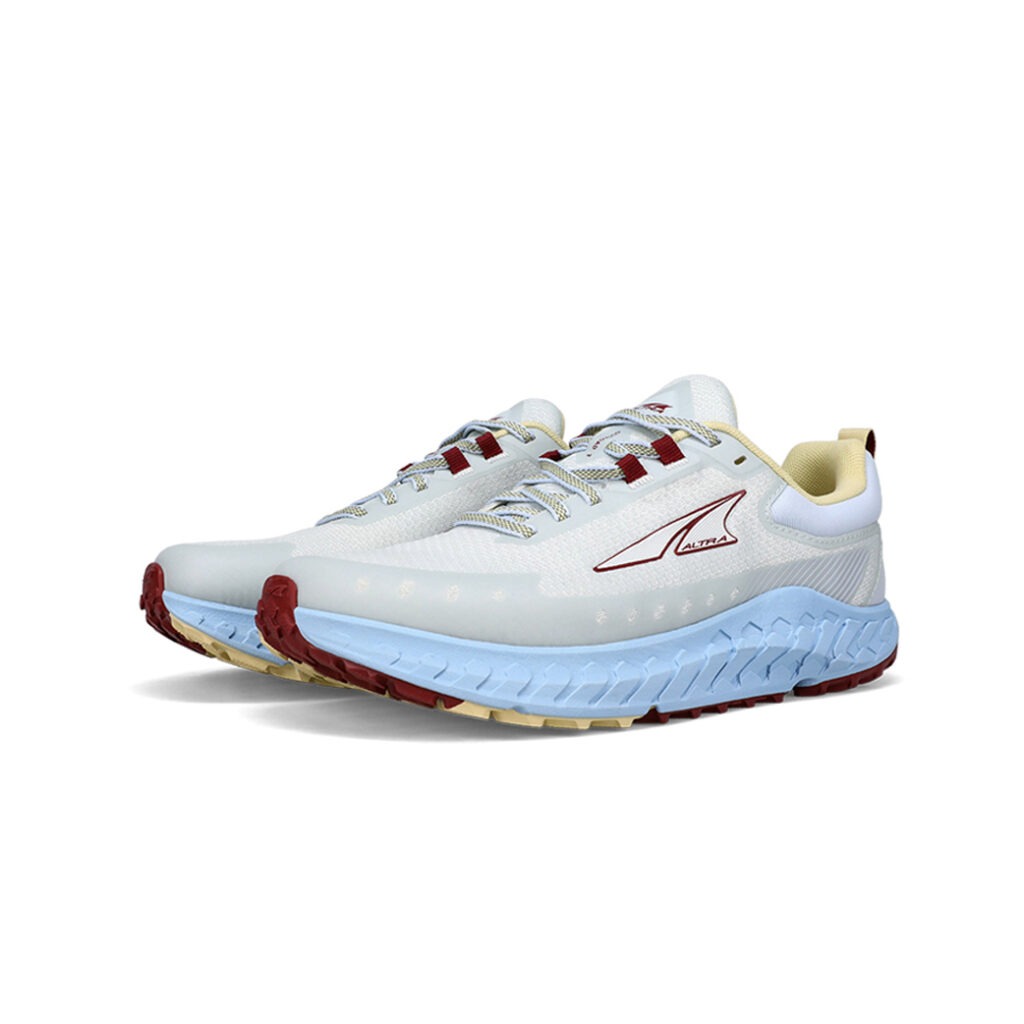 Die Altra Outroad 2 Damen Sneakers in hellblau mit roten Akzenten, ausgestattet mit einer atmungsaktiven Oberseite und robusten Gummisohlen für verbesserten Halt auf verschiedenen Untergründen.