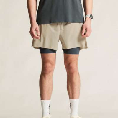 Craft Hypervent 2-in-1 Short für Männer in Sandfarben mit integrierten blauen Funktionsshorts, gefertigt aus leichtem, atmungsaktivem Material, ideal für sportliche Aktivitäten.