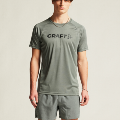 Craft Core Essence Tee für Männer in grauer Farbe, aus einem leichten, atmungsaktiven Material, mit dem Logo "CRAFT" auf der Brust. Das Sportshirt eignet sich für verschiedene sportliche Aktivitäten.