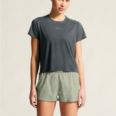 Craft Hypervent Tee Damen in dunkelgrau aus leichtem und atmungsaktivem Material, mit kurzem Arm und rundem Halsausschnitt, abgebildet mit sportlichen Shorts.