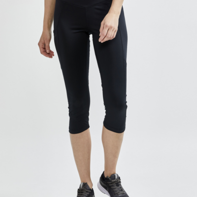 Craft Essence Capri Tight in Schwarz, hergestellt aus elastischem Material, mit einer mittelhohen Taille und einem bequemen, schmalen Schnitt, ideal für sportliche Aktivitäten, getragen von einer Frau in Sportbekleidung.