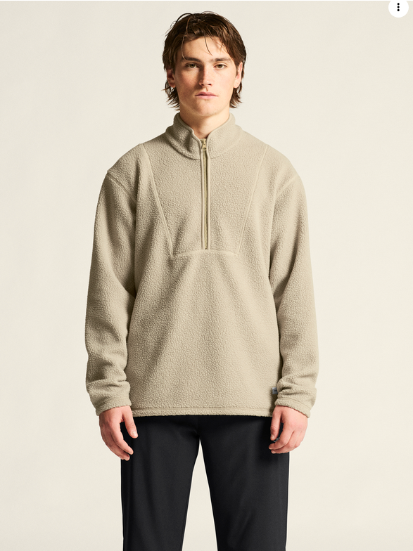 Craft Core Essence Tee men’s sport shirt in gray, shown on a model with a beige half-zip collar and long sleeves.